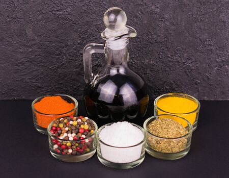 Soy sauce in a decanter and various spices on a black background. Close-up.の写真素材