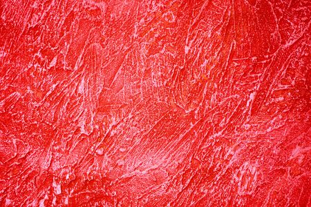 Uneven red stucco on the wall. Red ribbed wall texture.