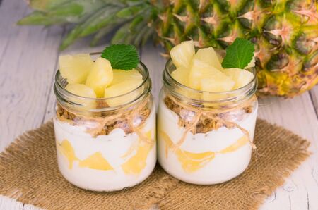 Two jars of homemade pineapple yogurt. A concept of light and healthy desserts.の写真素材