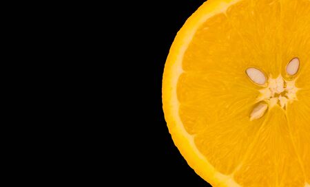One slice of orange isolated on black background. Close-up. Copy space.の写真素材