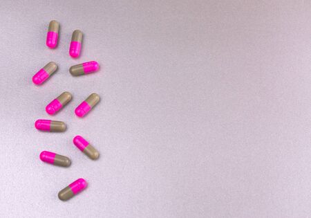 Capsules, pills (colored) on gray background. Copy space.の写真素材