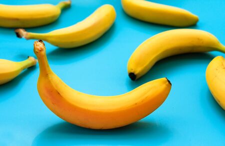 A lot of yellow bananas on a blue background.の写真素材