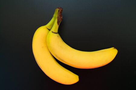 Two bananas isolated on a black background. Close-up.の写真素材