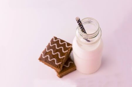 Bottle of milk and chocolate cake on a white background. Seeing from the top. Copy space.の写真素材