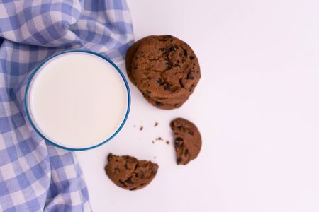 Glass of milk and chocolate chip cookies on a white background. Copy space. Flat lay.の写真素材