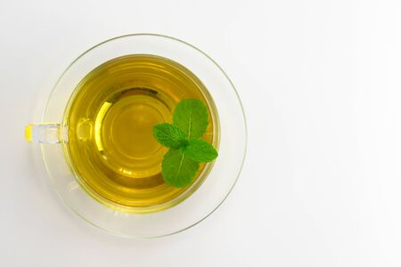 Mint tea in a transparent cup is isolated on a white background. Flat lay. Copy space.の写真素材