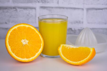 Freshly squeezed orange juice in a glass on a white background.