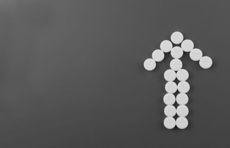 Arrow of white pills on a gray background. Copy space. Flat lay.の写真素材