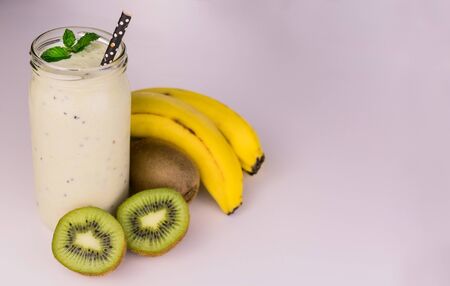 Kiwi and banana smoothies in a jar on a white background. Copy space.の写真素材