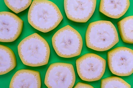 A lot of banana slices on a green background. Background of banana slices.の写真素材