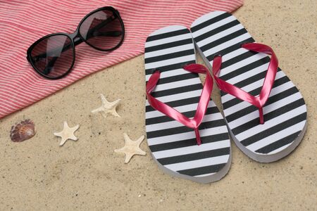Flip flops and sun glasses in the sand. Summer vacation concept.の写真素材