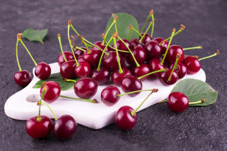Ripe red cherry on a white wooden board.Close-up.