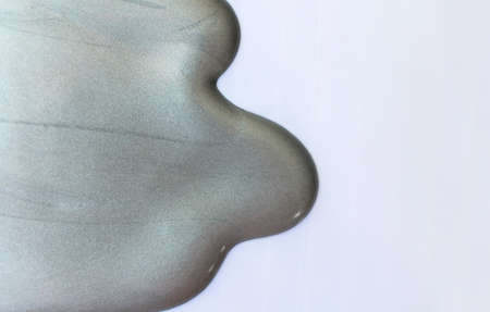 Silver paint spreads on white background.Copy space.の写真素材