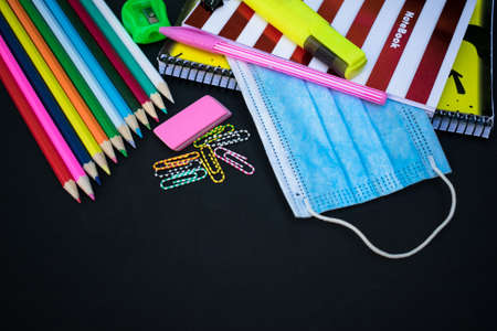 School supplies and medical mask, school opening, return to school after COVID-19 pandemic, new normal concept. Copy space.の写真素材