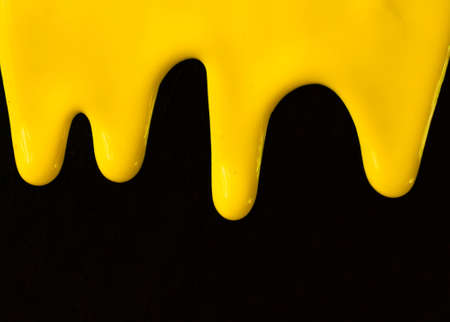 Yellow paint on a black background. Copy space.の写真素材