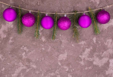 Christmas balls and branches of a Christmas tree on a background of a gray wall.Copy space.