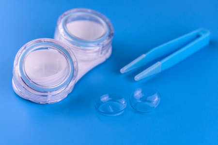 Container for contact lenses and lenses on a blue background. Close-up.の写真素材