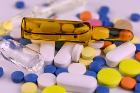 Medical background from ampoules and pills on a white background. Close-up.の写真素材