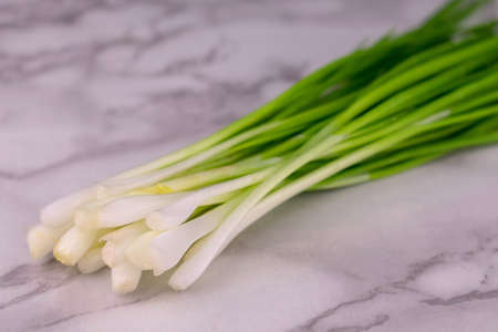 Green onions on a white marble background. Close-up.の写真素材