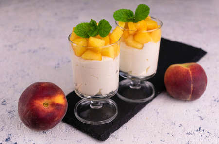 Light dessert with peach and cream cheese on a white plate.の写真素材
