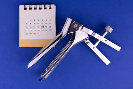 Gynecological speculum and date stamped calendar. Concept of the term at the gynecologist.の写真素材