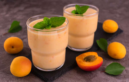 Apricot smoothie on a gray background. Two glasses of apricot smoothie.の写真素材