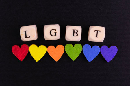 LGBT community lettering and small hearts in the colors of the LGBT flag on a black background.の写真素材