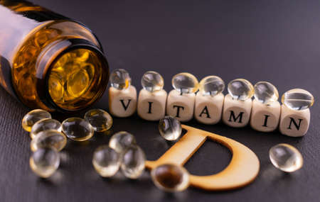 Lots of vitamin D3 gel capsules on a black background. Selective focus.の写真素材