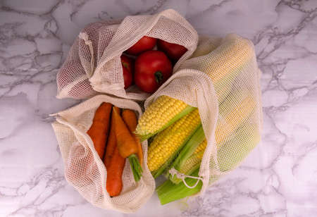 Zero waste shopping concept. Vegetables in eco-cotton bags on the table. Plastic rejection concept.