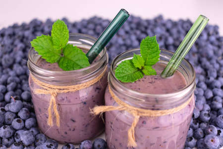 Blueberry smoothies in jars on a background of blueberries.の写真素材