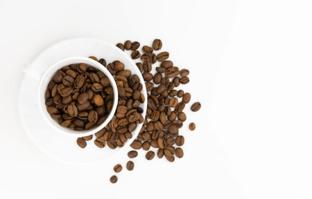Grains of coffee in a cup on a white background. View from above. Copy space.の写真素材