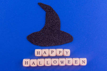 Black witch hat and inscription Happy Halloween on a blue background.の写真素材