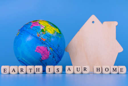 Globe and House on Blue Background Save Planet Earth Conceptの写真素材