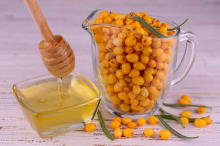 Fresh sea buckthorn berries and honey. Close-up.の写真素材