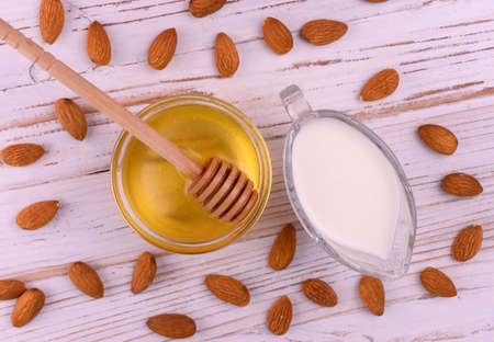 Milk from almonds on a white wooden background. Flat lay.