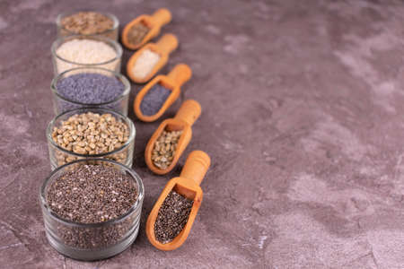 Various seeds - sesame, flax, poppy, hemp, chia and dill bowls on a gray background. Copy space.の写真素材