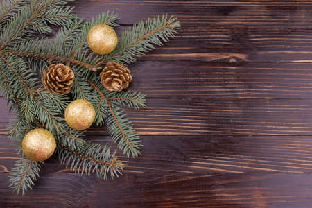 Christmas tree with cones about golden balls on a wooden background. Copy space.の写真素材