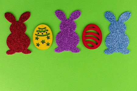Easter background from decorative eggs and bunnies on a green background.Copy space.