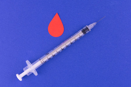 Insulin syringe and a drop of blood. Diabetes disease concept.の写真素材