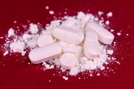 Crushed pills on a red background. drug abuse. close-up