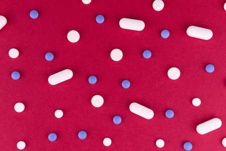 Medical background.Many pills on a red background.