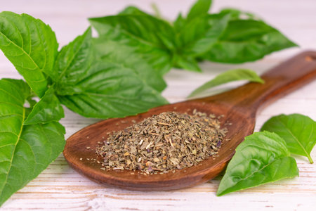 Dry basil in a wooden spoon. natural spices.の写真素材