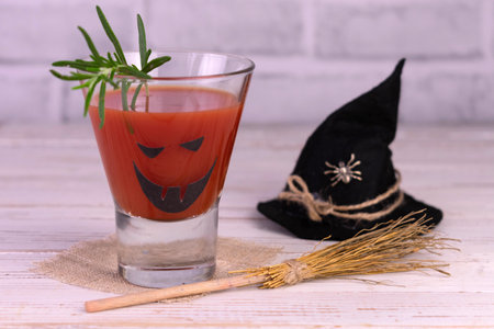 Halloween drink idea. Freak Monster Tomato Juice Cocktail. Jack-o-lantern face on a glass.の写真素材
