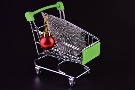 Christmas tree in a supermarket trolley on a black backgroundの写真素材
