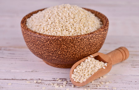 Sesame seeds in a wooden bowl on a white background.Close-up.の写真素材
