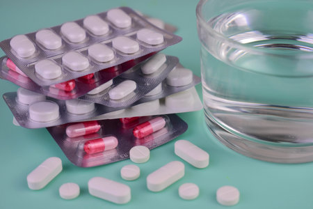 Many pills and a glass of water. medical background.の写真素材