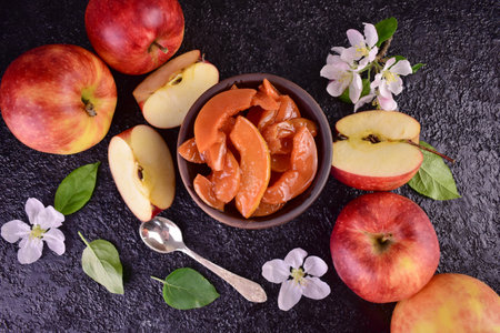 Homemade canned apples with apricot jam on a dark background. Selective focus.の写真素材