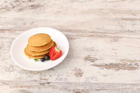 Pancakes with fruit. Breakfast with punkcakes. Pancakes in a pile on a plate.