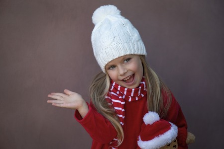 Happy little girl smiling with a Christmas bear. Happy girl holding a Christmas bear.の写真素材