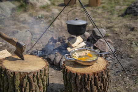 Cooking on a fire. Fish soup on a fire. Food in a cauldron on a fire. Food outdoors. Cooking outdoors. Cooking in nature on the cauldron.の写真素材